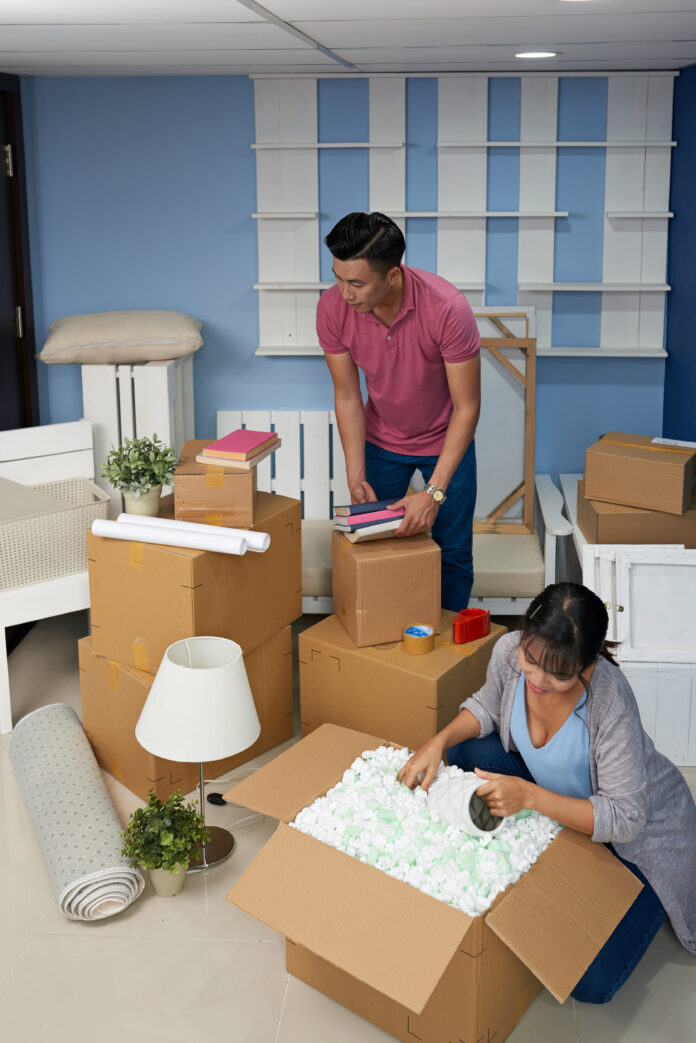 Couple Unpacking Boxes At Home Image showcasing renter-friendly storage solutions, including stackable bins, wall-mounted shelves, under-bed storage, and modular furniture in a modern living space.