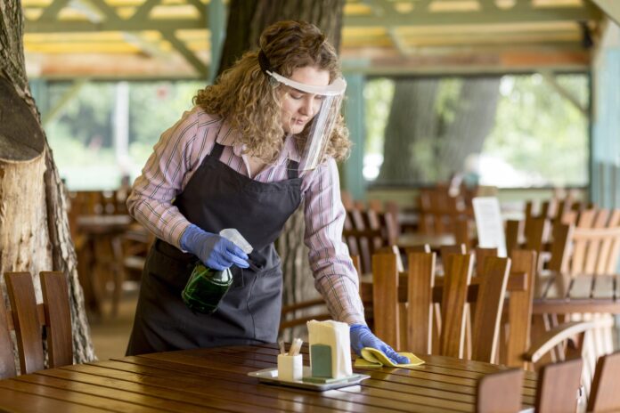 A beautifully stained wooden table being cleaned with a soft cloth, showcasing proper care and maintenance techniques for stained furniture.